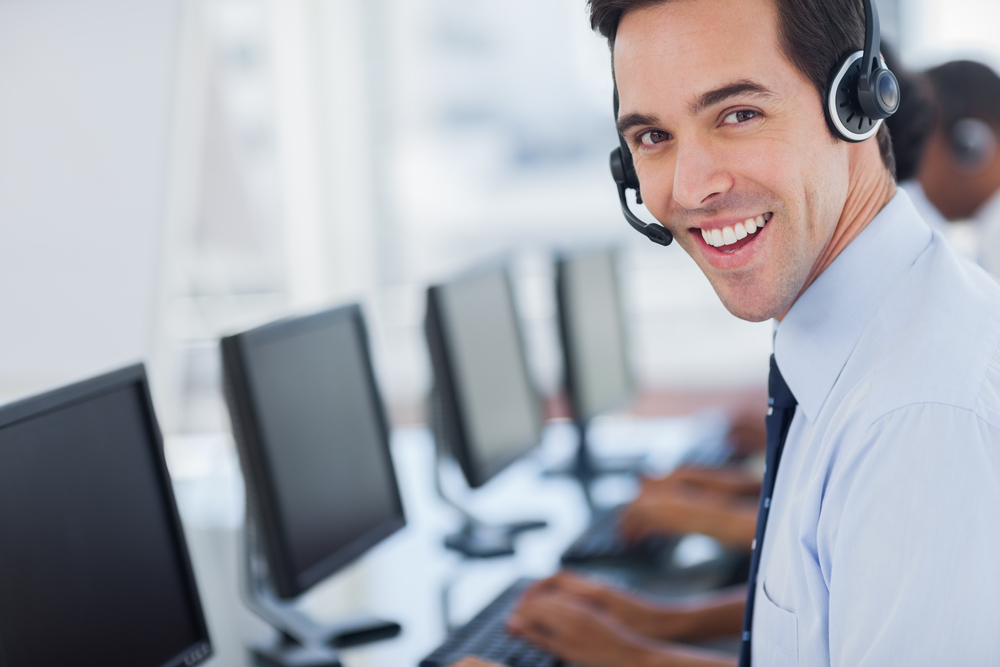 Focus on a joyful call centre agent with his headset